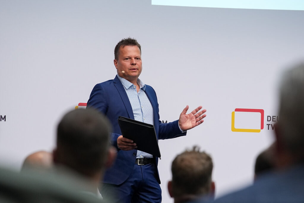 Dr. Jörn Krieger bei der Moderation der MIP#6 auf der Bühne im Jahr 2023